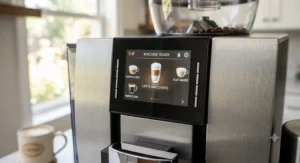 Close-up of the digital touchscreen control panel on a super automatic espresso machine displaying drink options like latte and Americano.