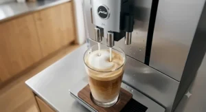 Jura fine foam frother pouring silky steamed milk into a glass latte macchiato