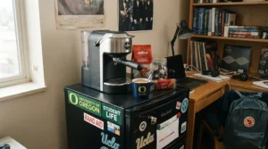 A budget-friendly compact thermoblock espresso machine for dorm rooms set up on a mini fridge top.